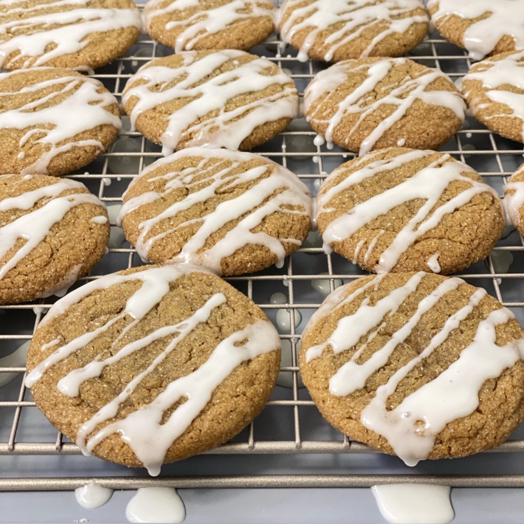 Iced ginger cookies on a wire cooling rack.