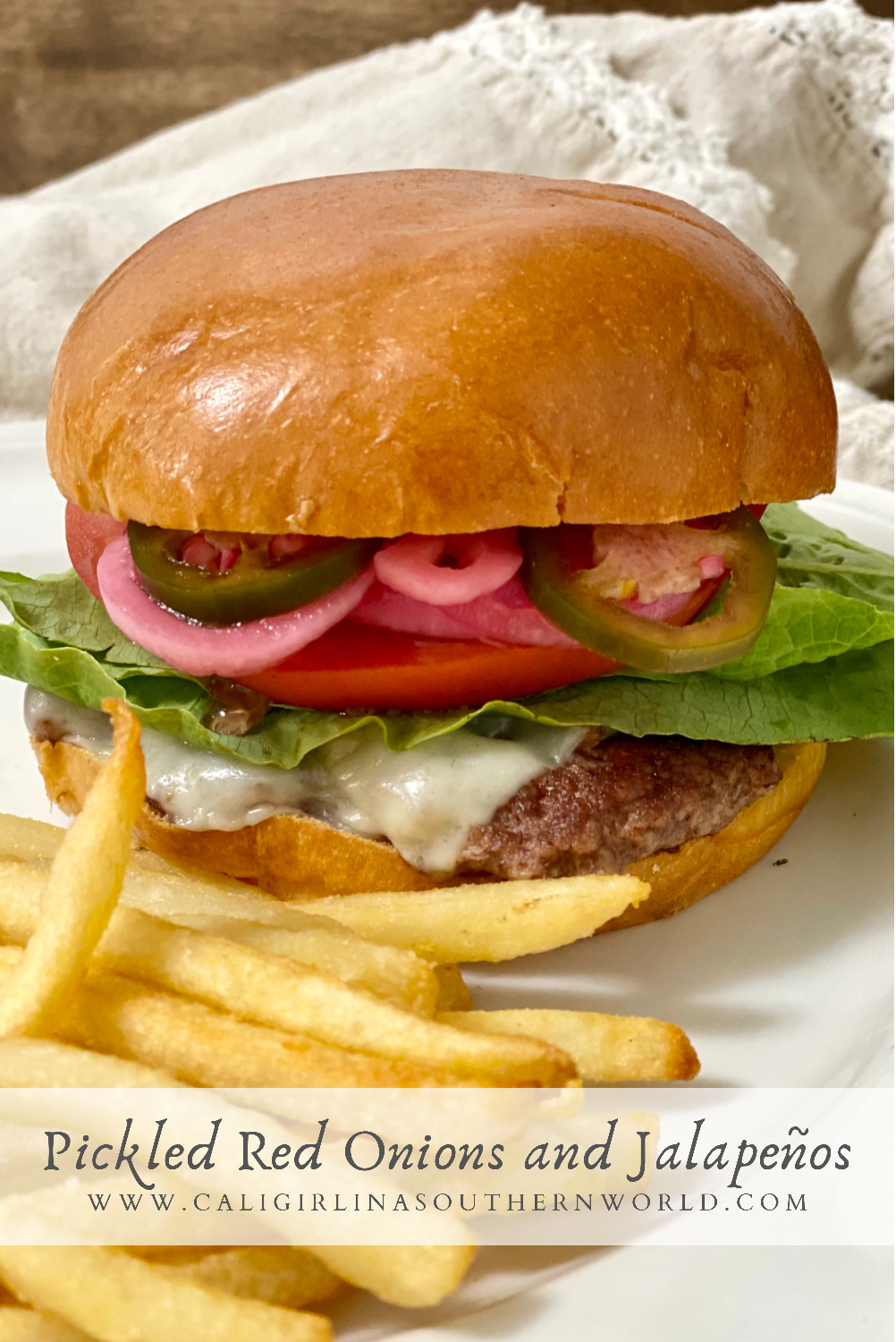 Pinterest Pin of a cheeseburger with pickled onions and jalapenos, lettuce, and tomato on it.