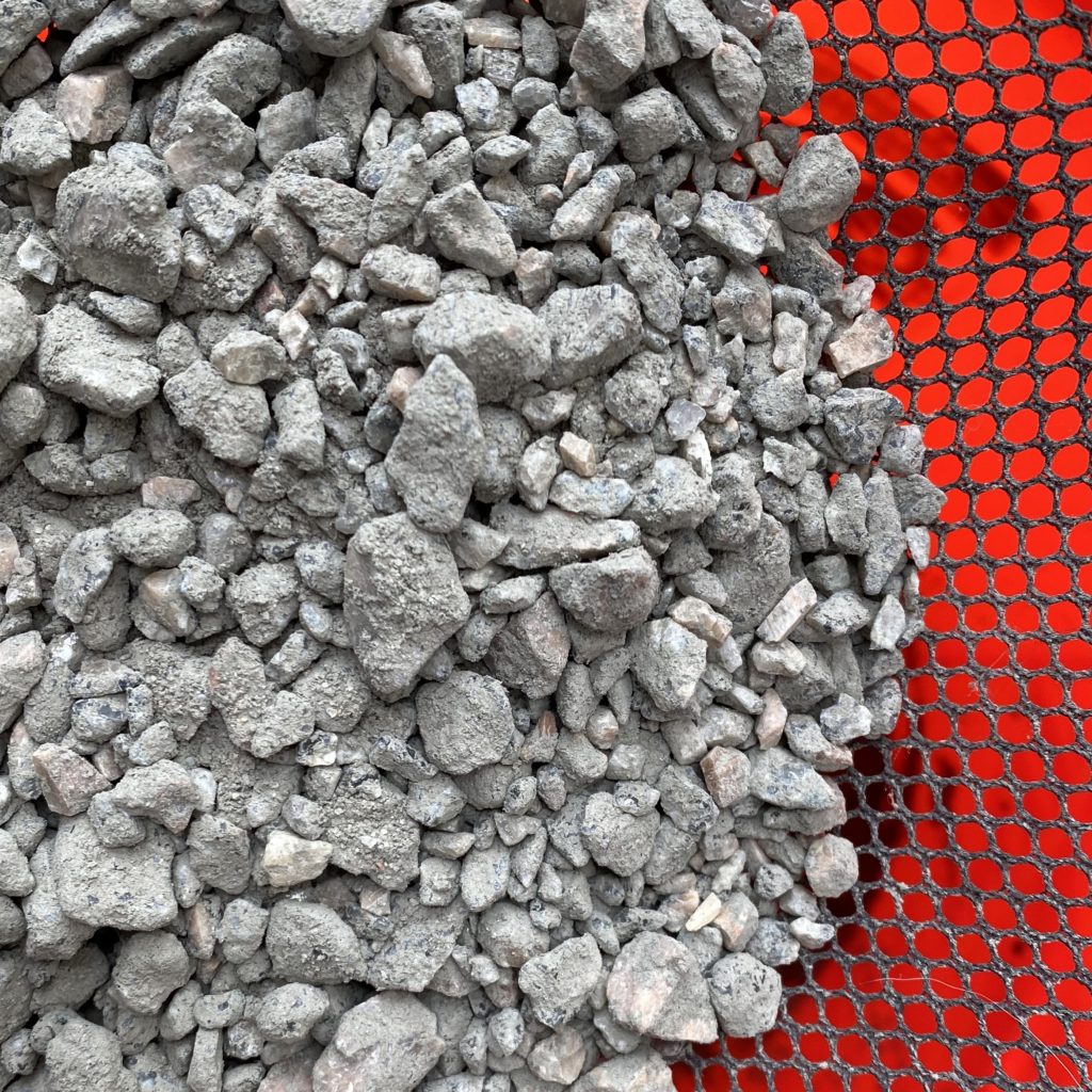 A close up photo of the rocks in the sifter that were sifted out of the concrete.