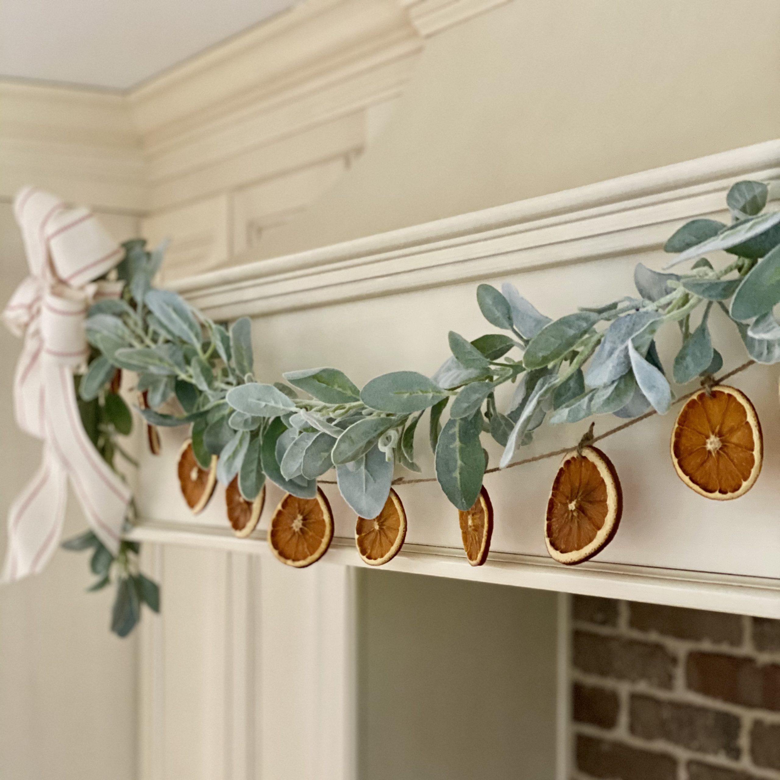 Close up of dried orange garland hanging on the hood in the kitchen over the stove.