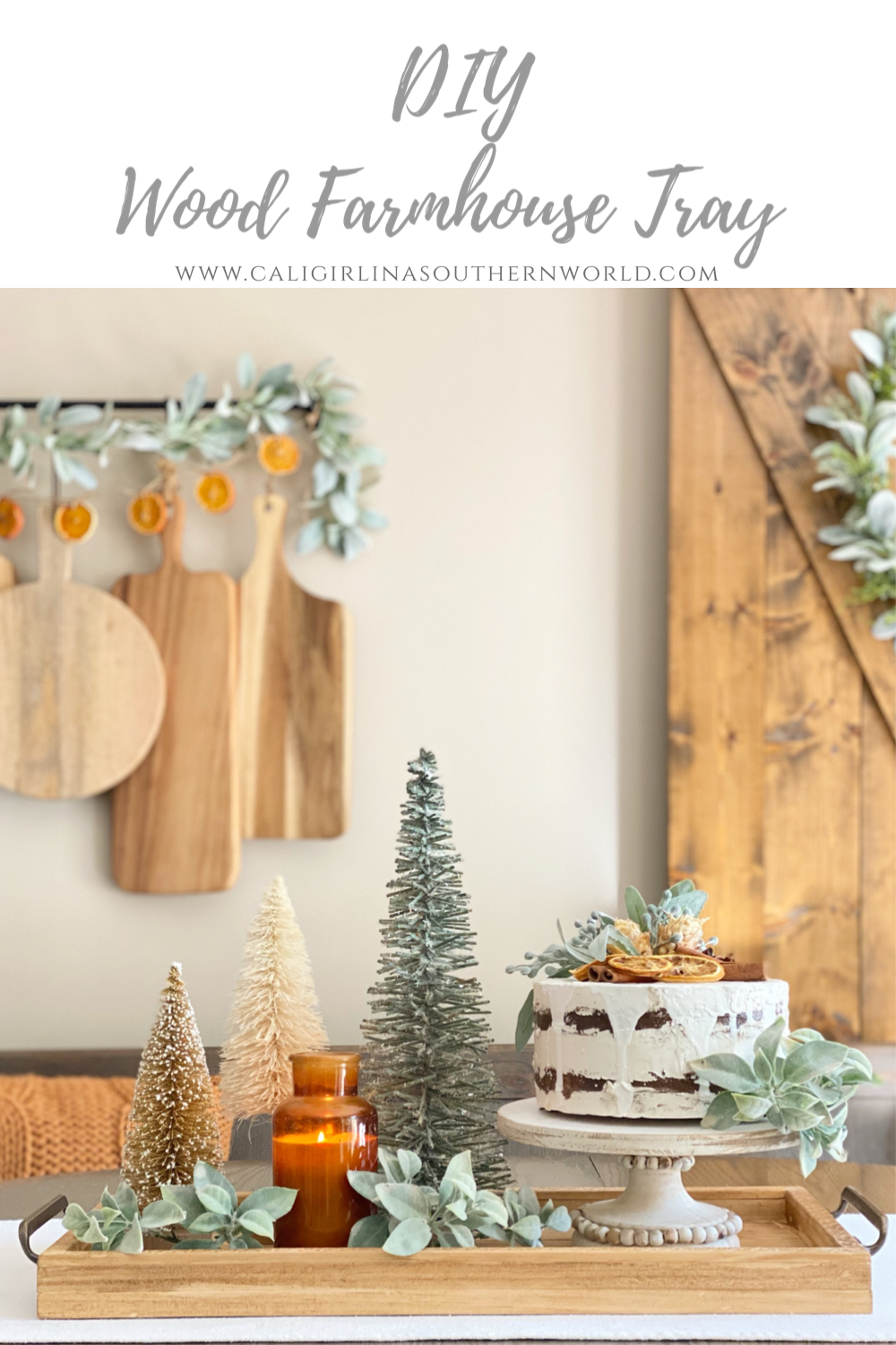 DIY wood farmhouse tray centerpiece styled with bottle brush Christmas trees, a candle, and a cake on it.