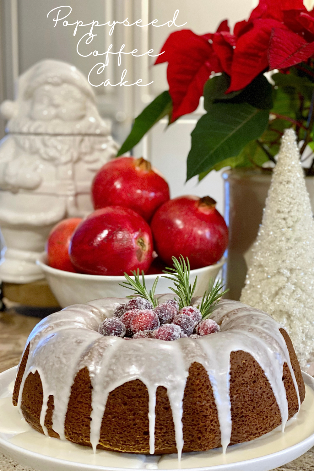 Poppyseed Coffee Cake displayed with Santa cookie jar, a bowl of pomegranates, and a poinsettia behind it.