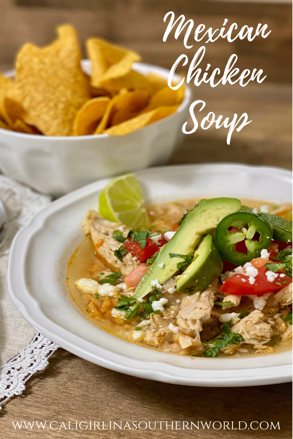 Mexican Chicken Soup in a white bowl with tortilla chips on the side.