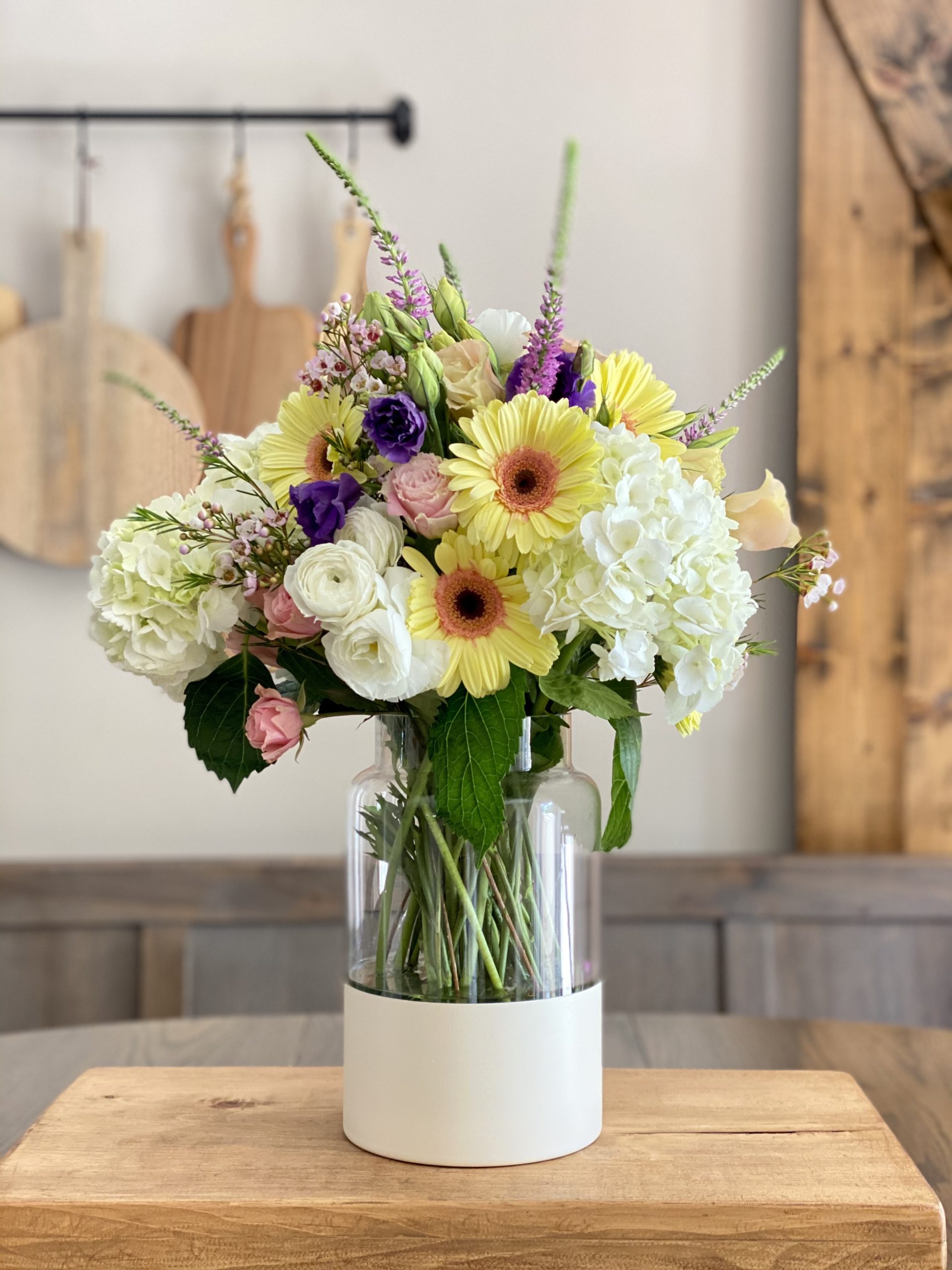 DIY Color Block Vase on a kitchen table with an arrangement in it of Spring florals. 