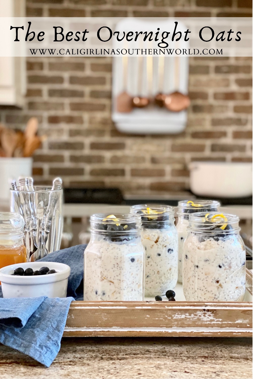 Pin for Pinterest of the best overnight oats on a tray in the kitchen with honey and blueberries.