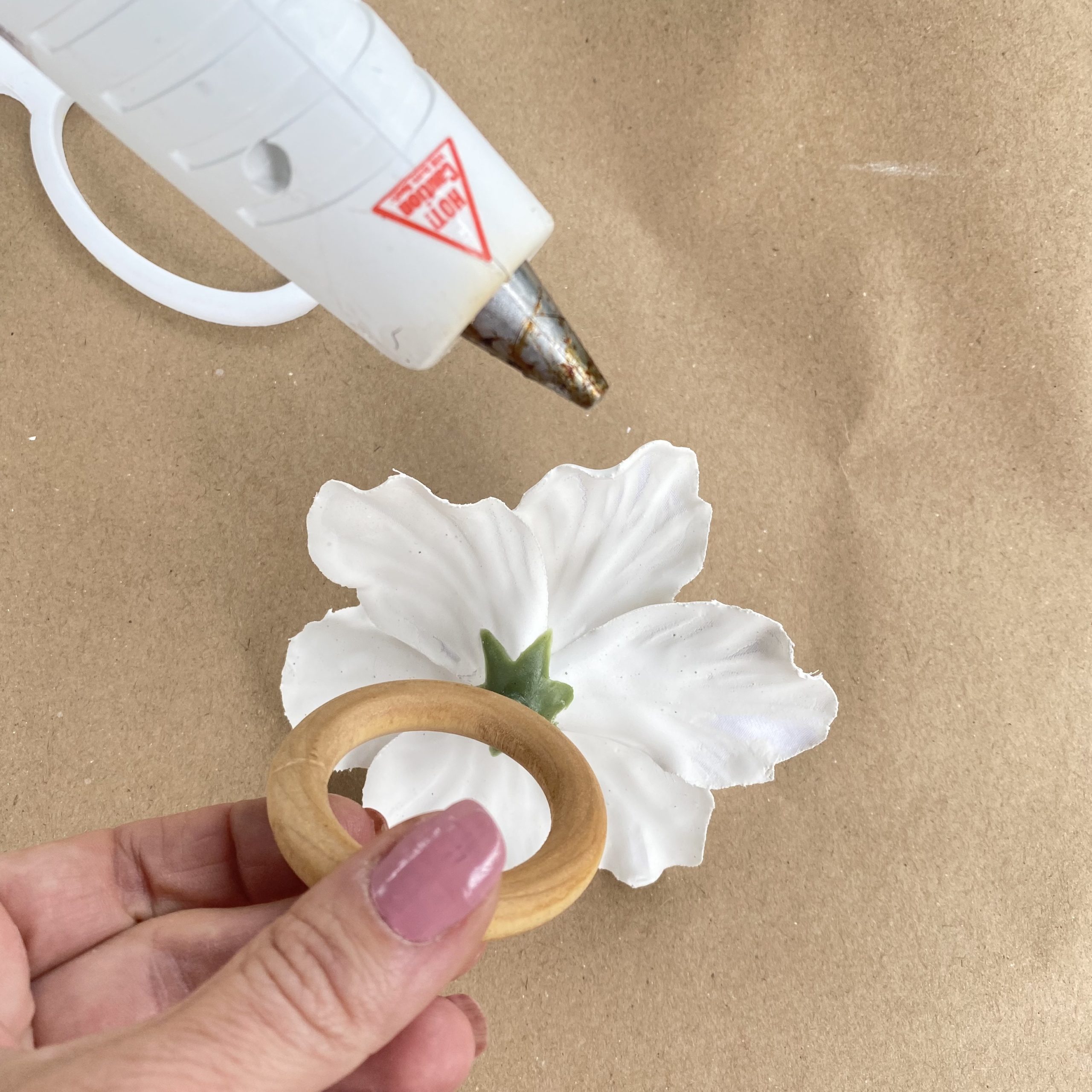 Hot gluing the napkin ring onto the plaster of paris flower.