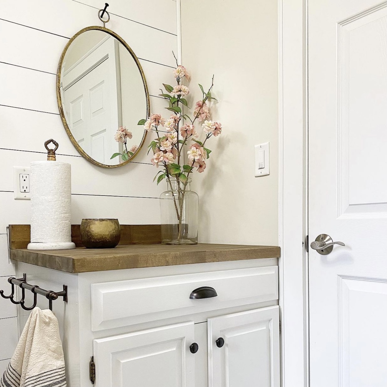 Farmhouse laundry room folding table with a mirror on the wall above it.