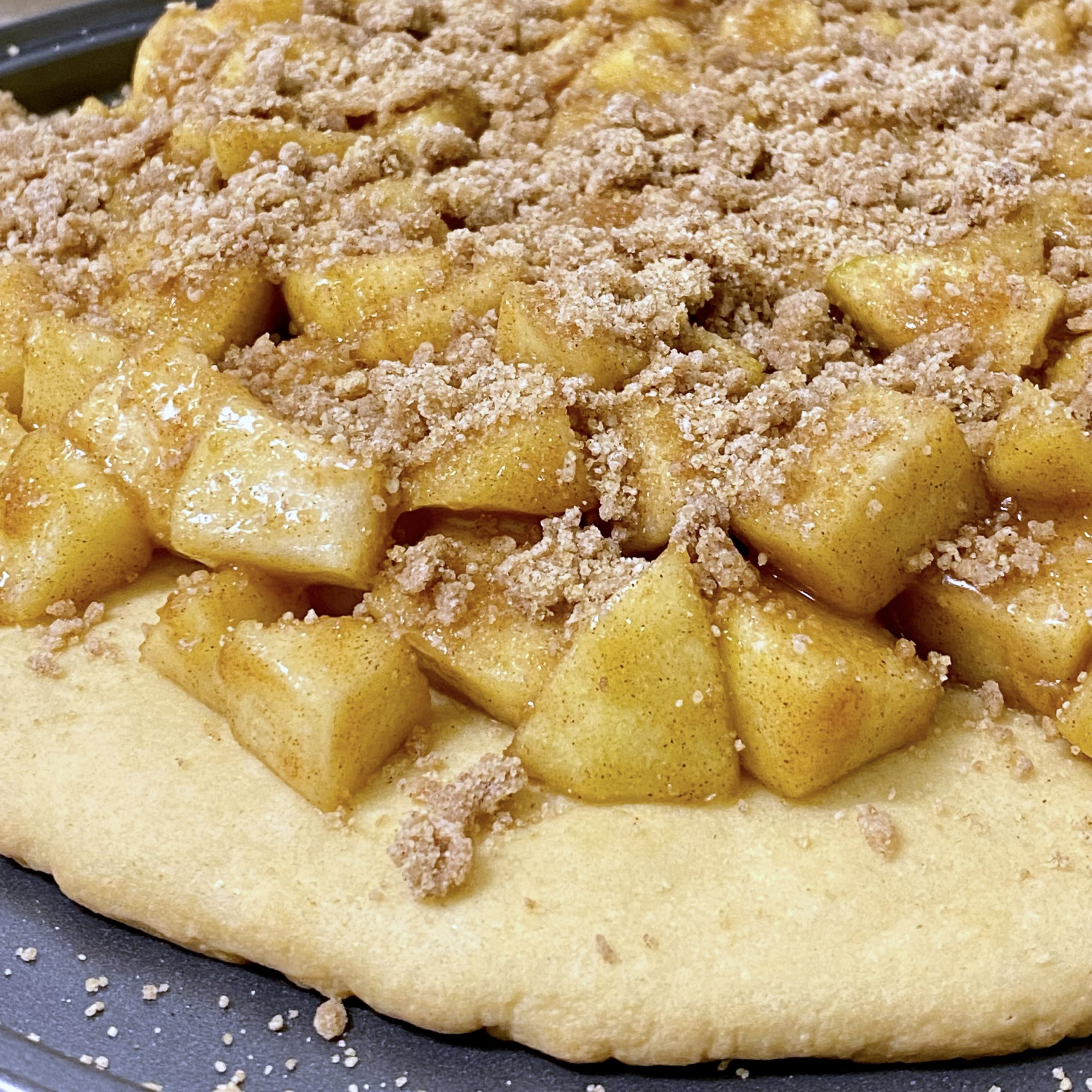 Apple Pie Pizza close up with apple pie filling and crumble topping close up.