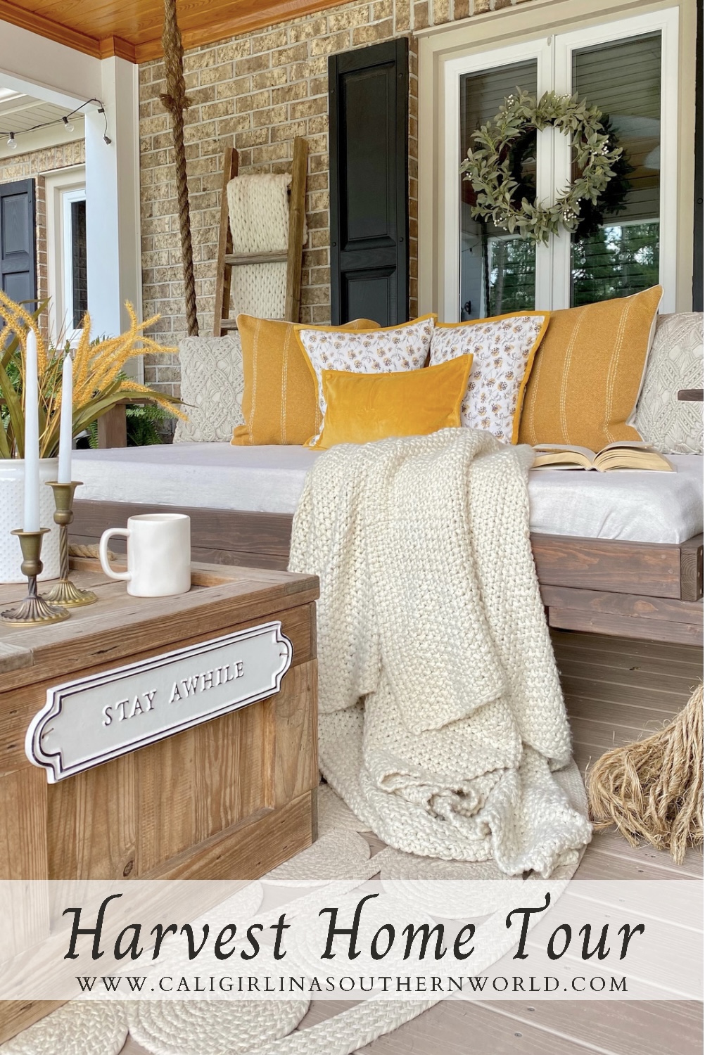 Front porch swing decorated for early fall with mustard yellow home decor accents, cream, and green.