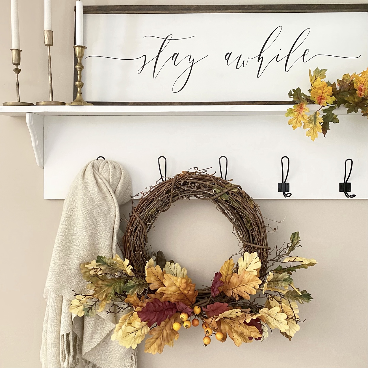 Fall wreath hanging from hooks in the foyer.