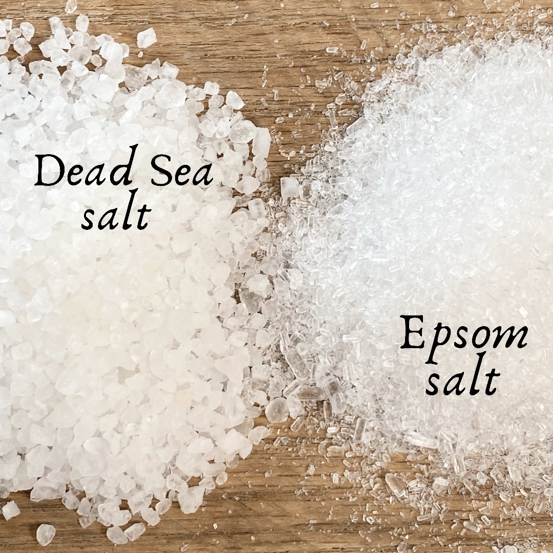 Dead Sea salt and Epsom salt on a wood board showing the visual difference between the two.