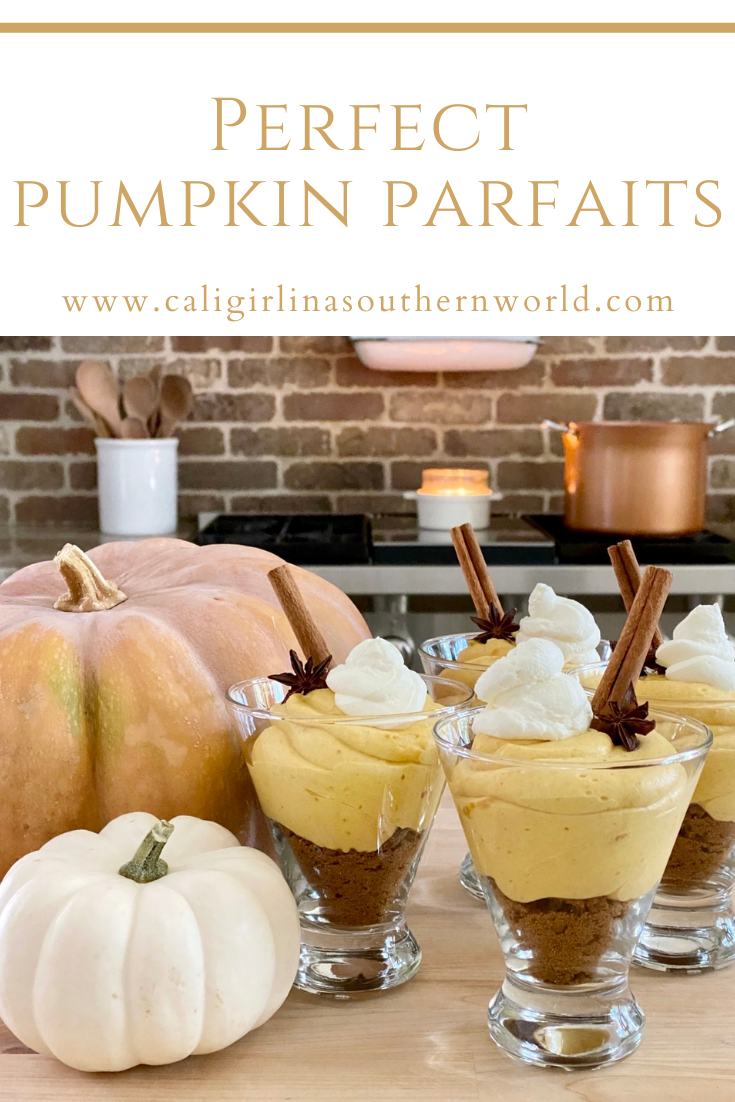 Pumpkin parfaits on the island with pumpkins next to them. In the background is the stove and a candle burning.