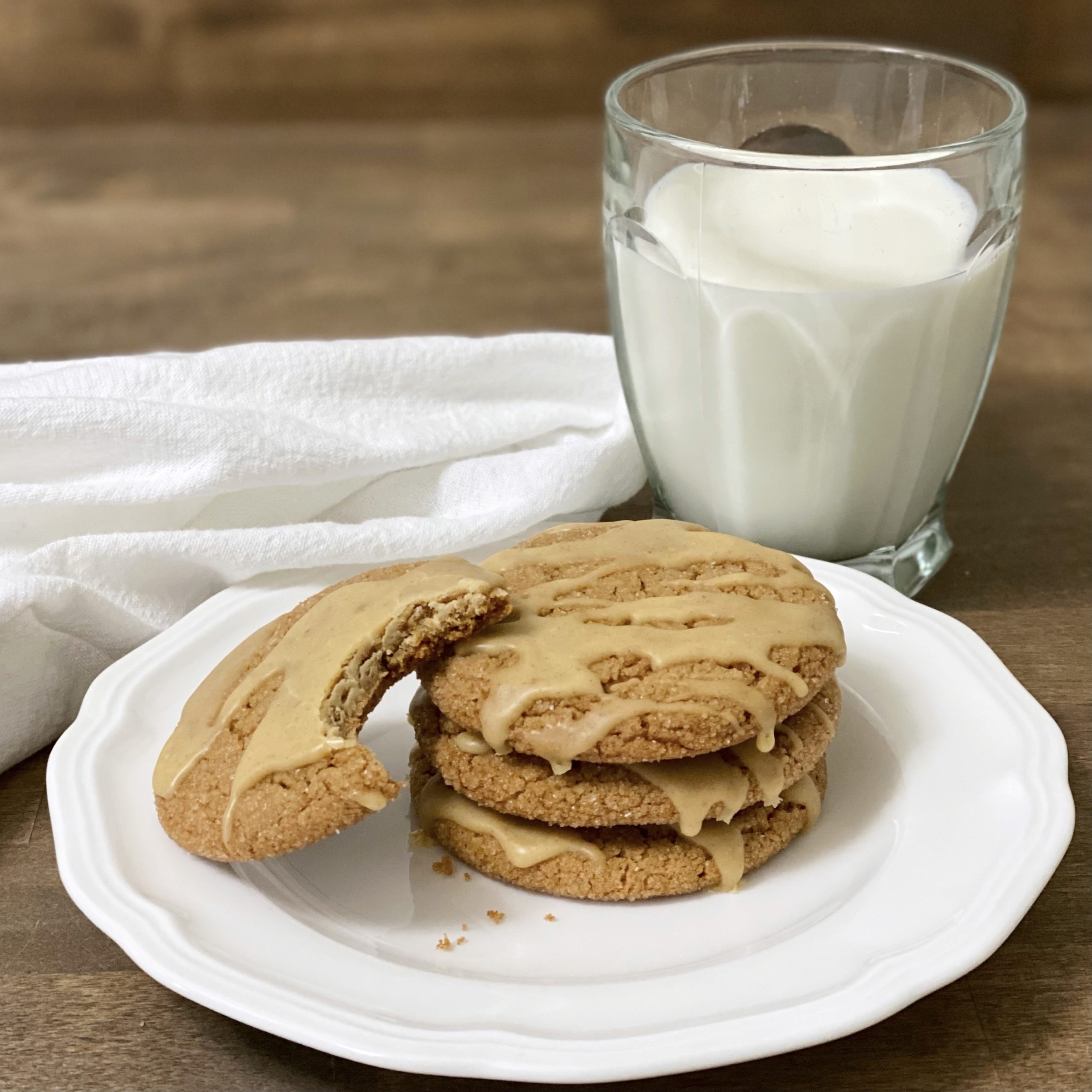 Pumpkin Spice Cookies on a white plate with a glass of milk next to it.