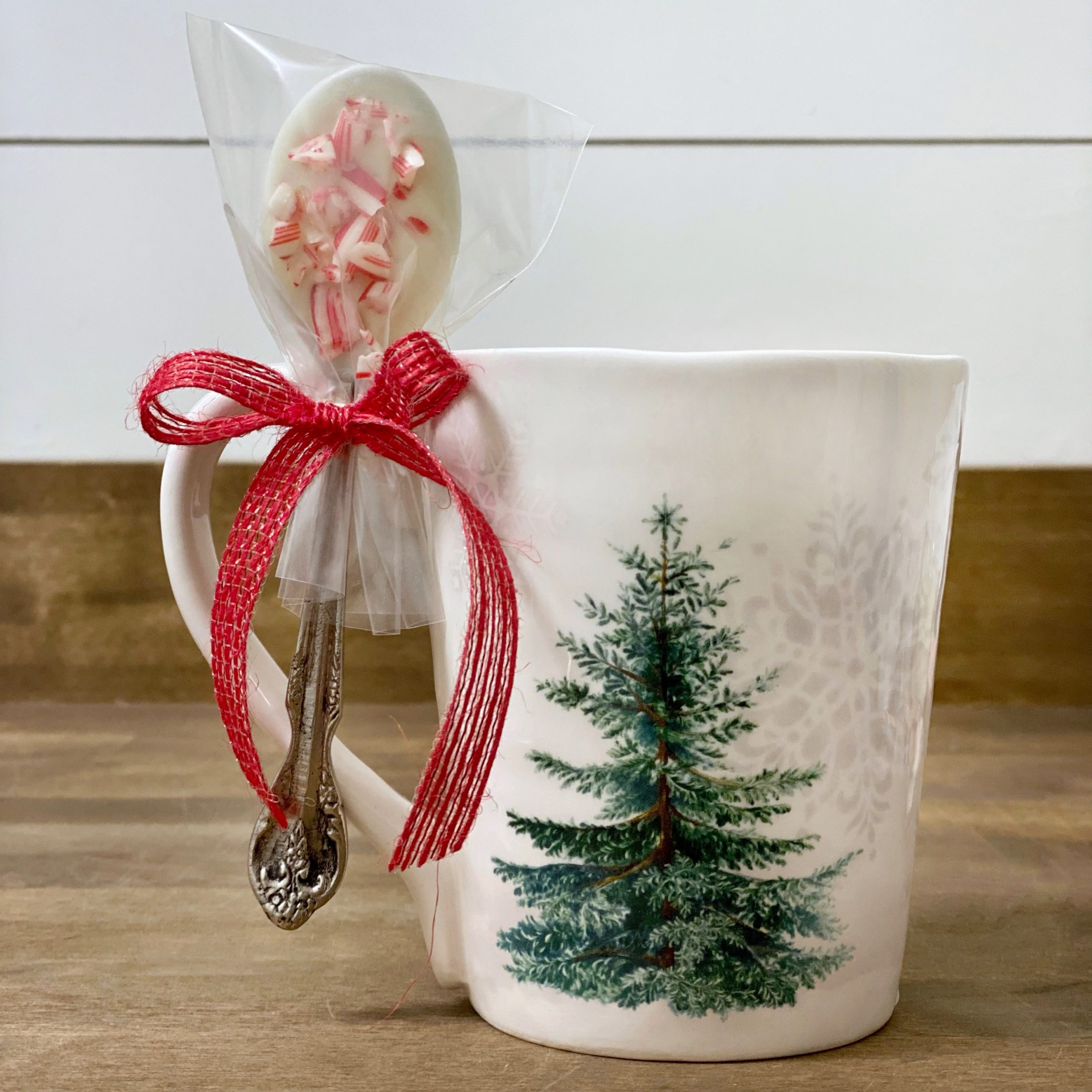 Christmas mug with a chocolate dipped spoon tied onto it. 