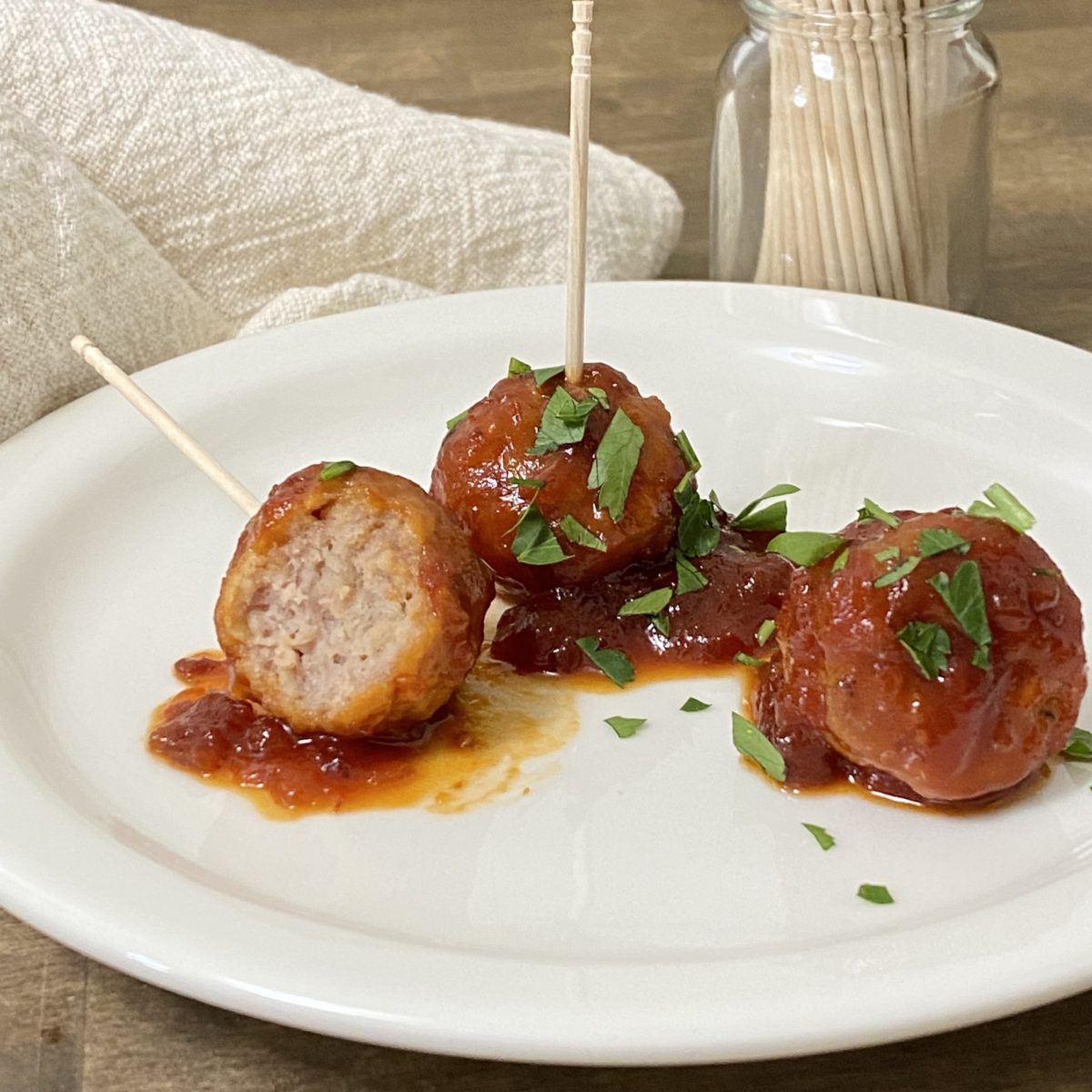 Meatballs on an appetizer plate with toothpicks.