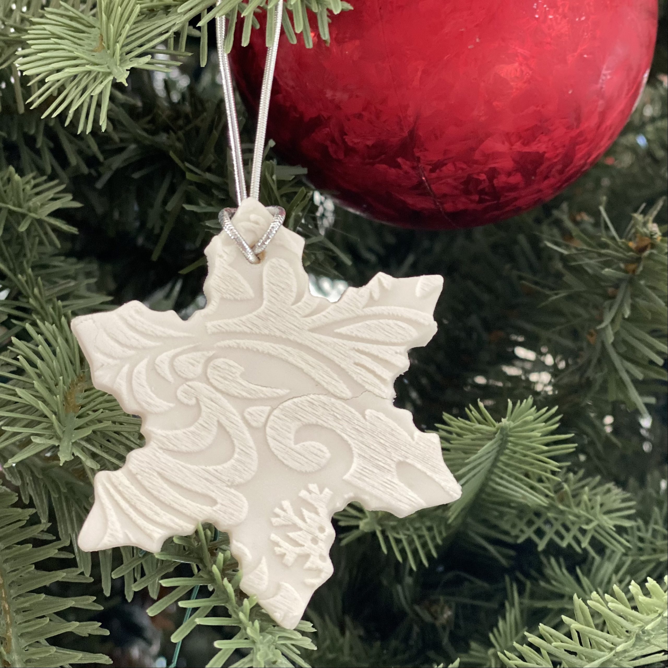 Baking soda dough snowflake ornament hanging on the Christmas tree.