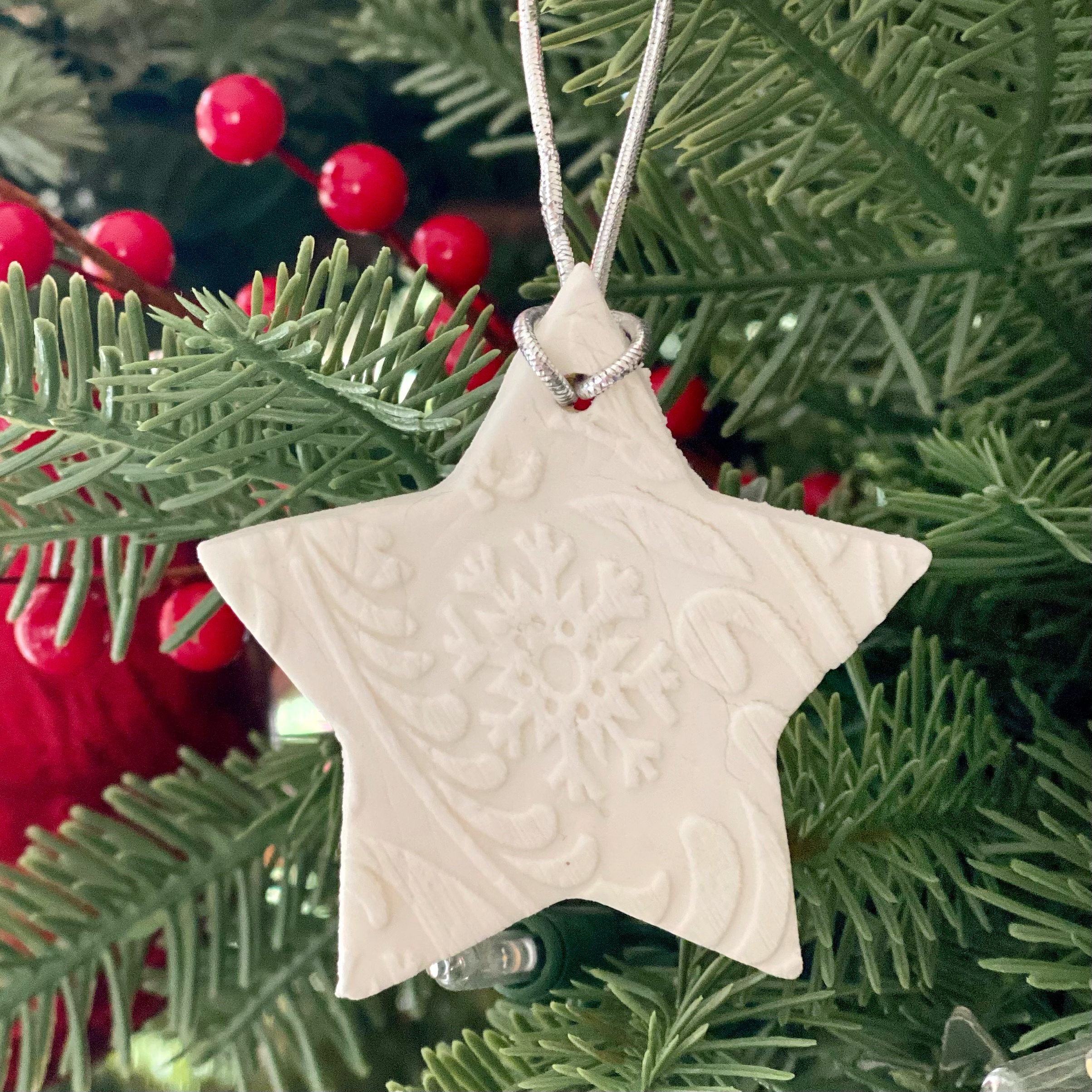 Baking soda dough star ornament hanging on the Christmas tree.