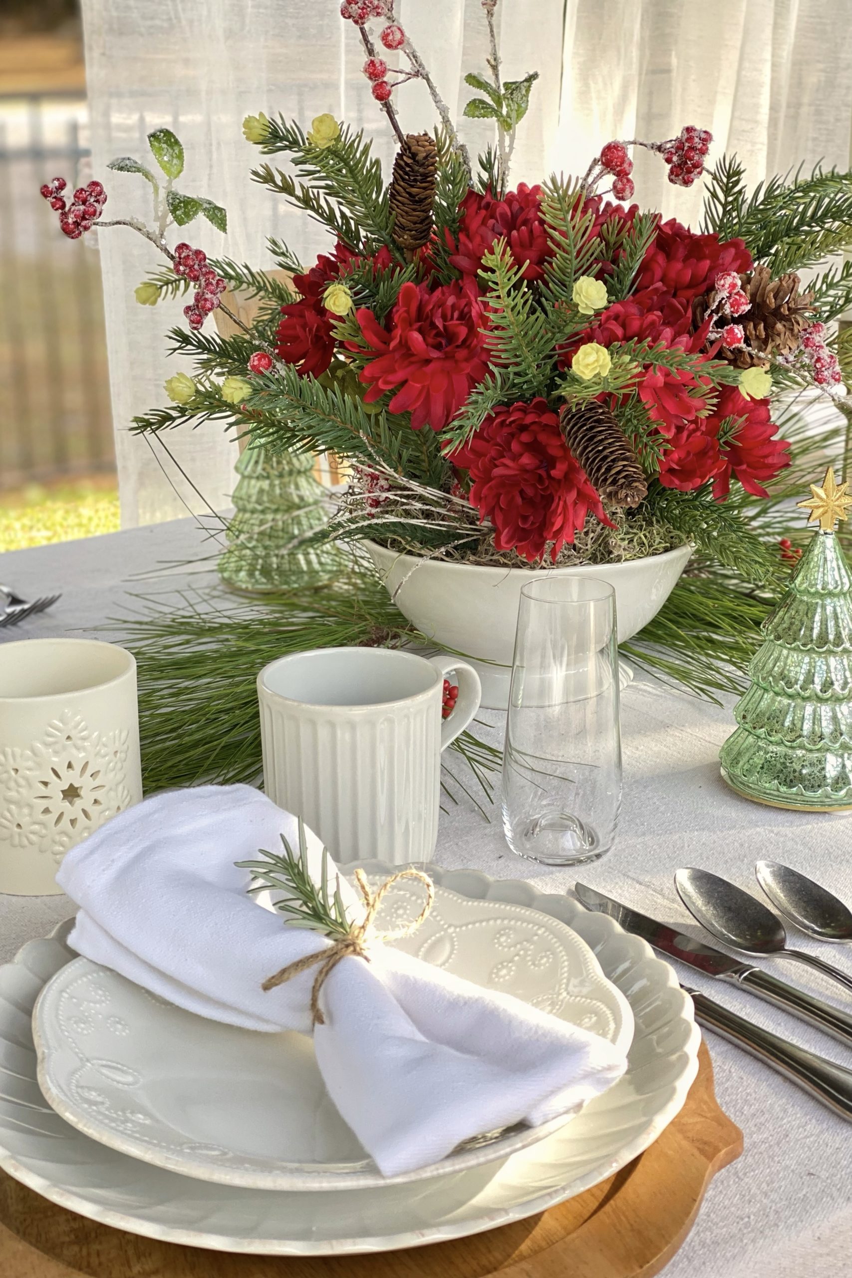 Holiday table setting featuring Lenox tableware and a Christmas floral arrangement.