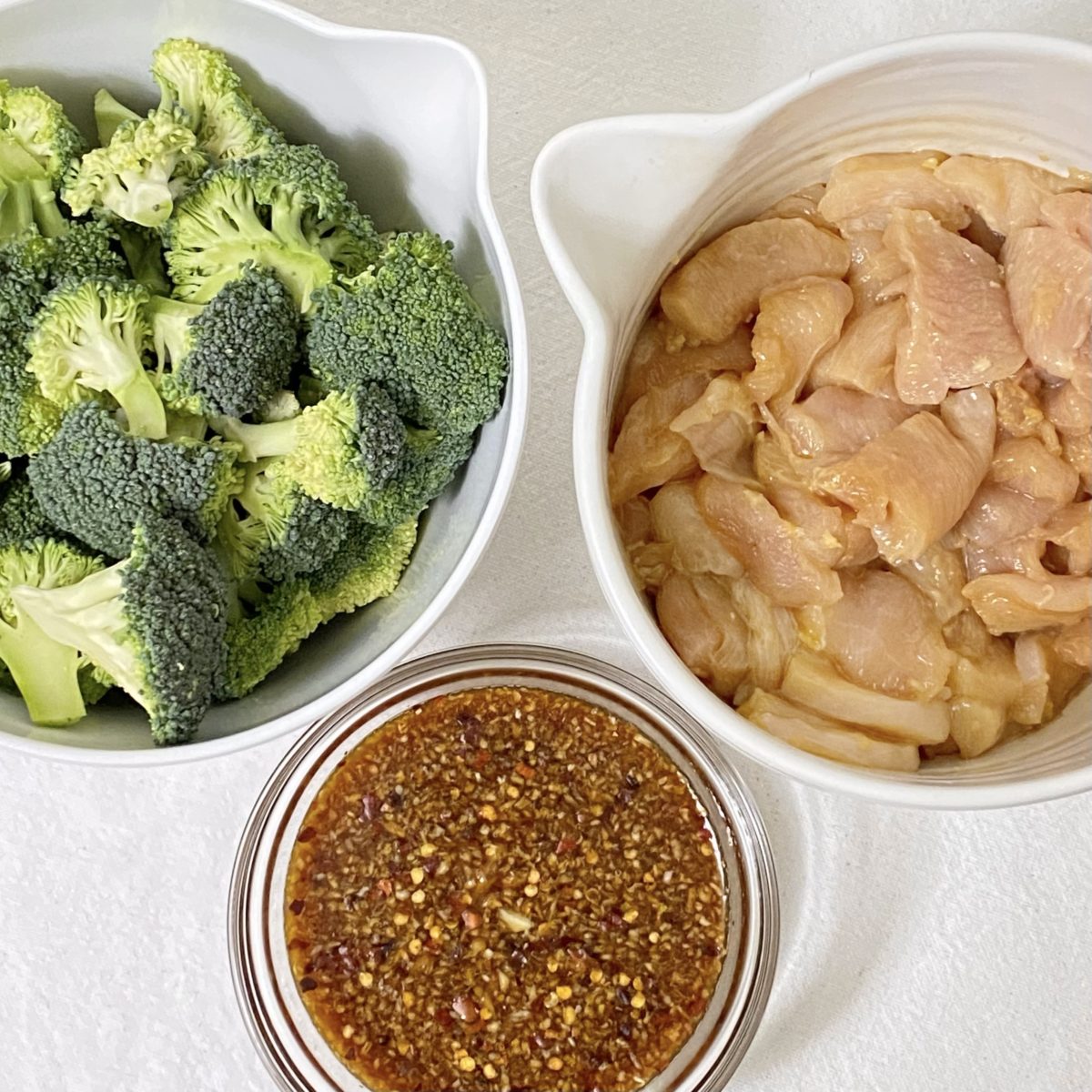 Broccoli, chicken, and honey garlic sauce in bowls.