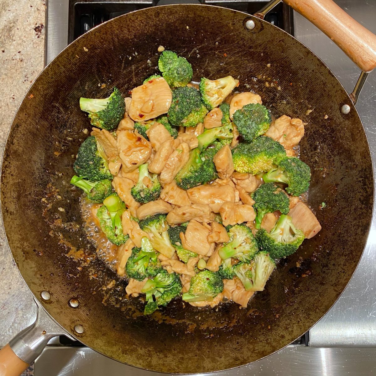 Honey garlic chicken with broccoli in a wok.