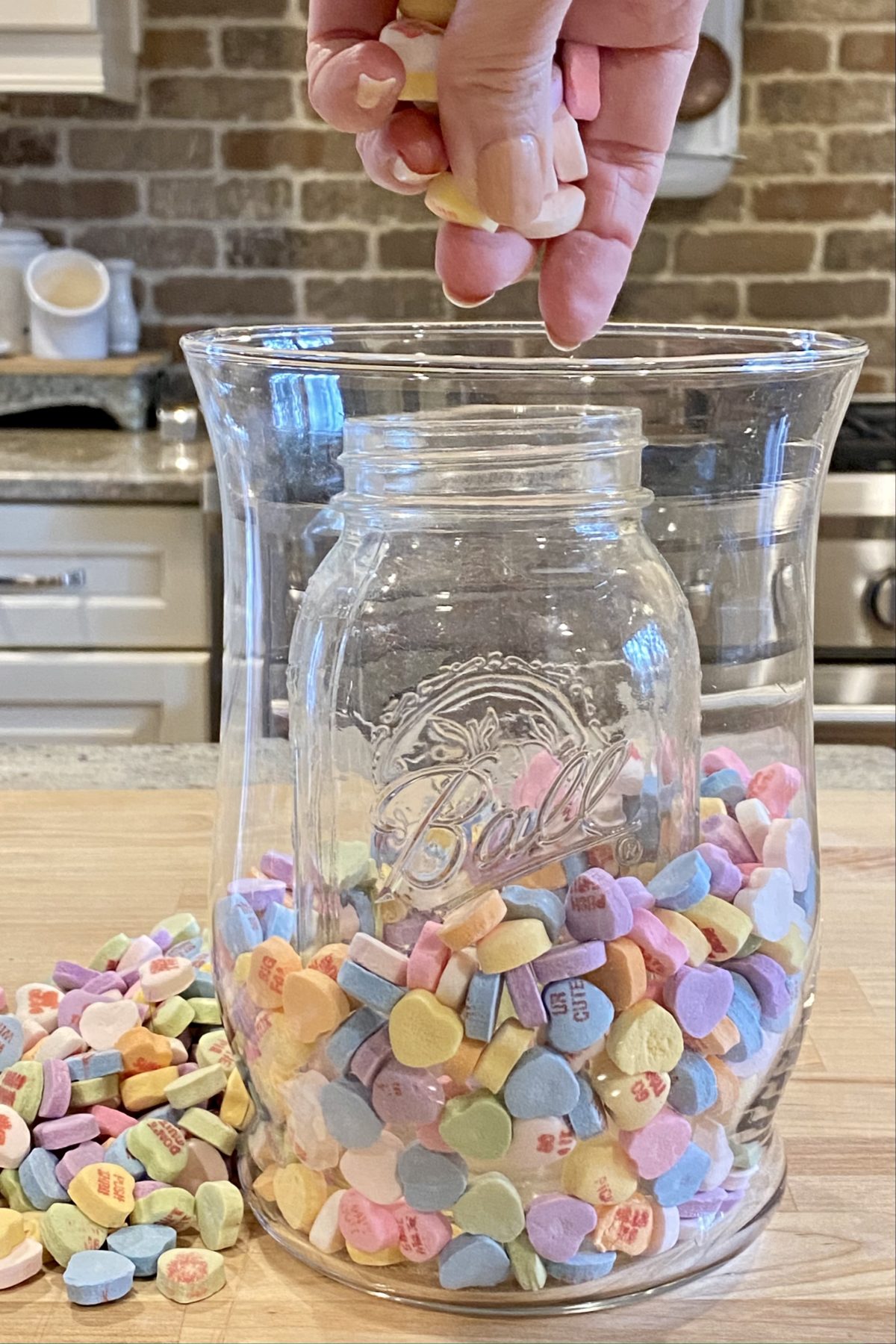 Filling the vase with candy hearts in between the large vase and the vase inside. 