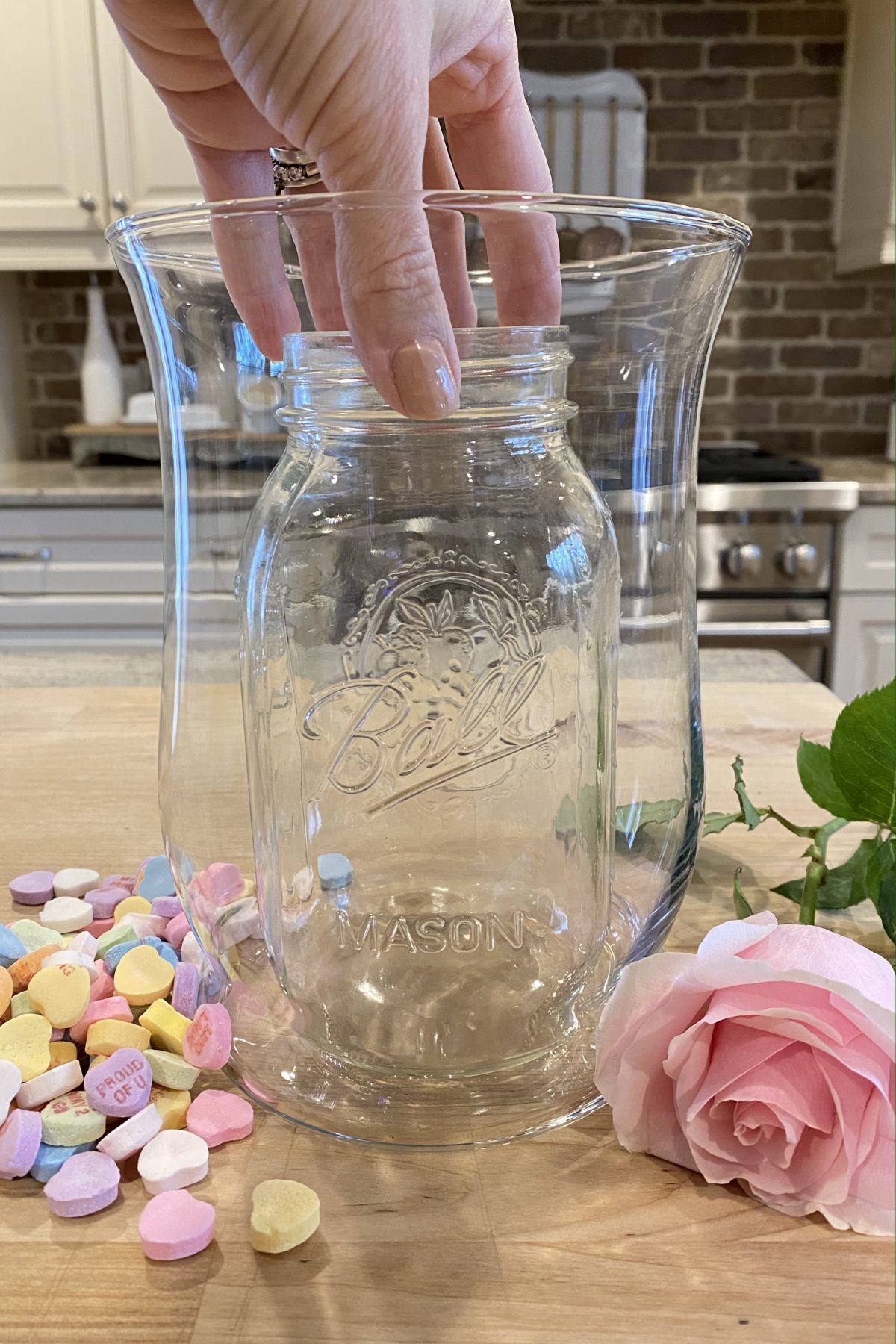 Placing a smaller glass jar inside a glass vase.