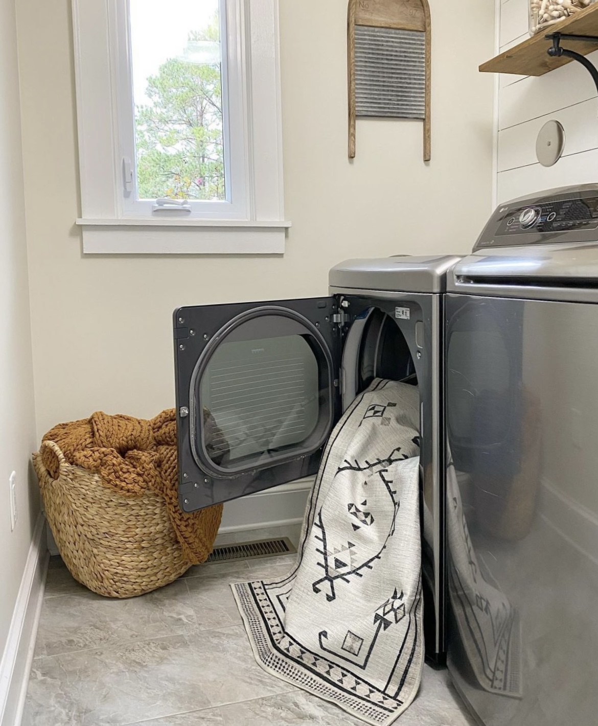 A washable rug coming out the dryer in the laundry room.