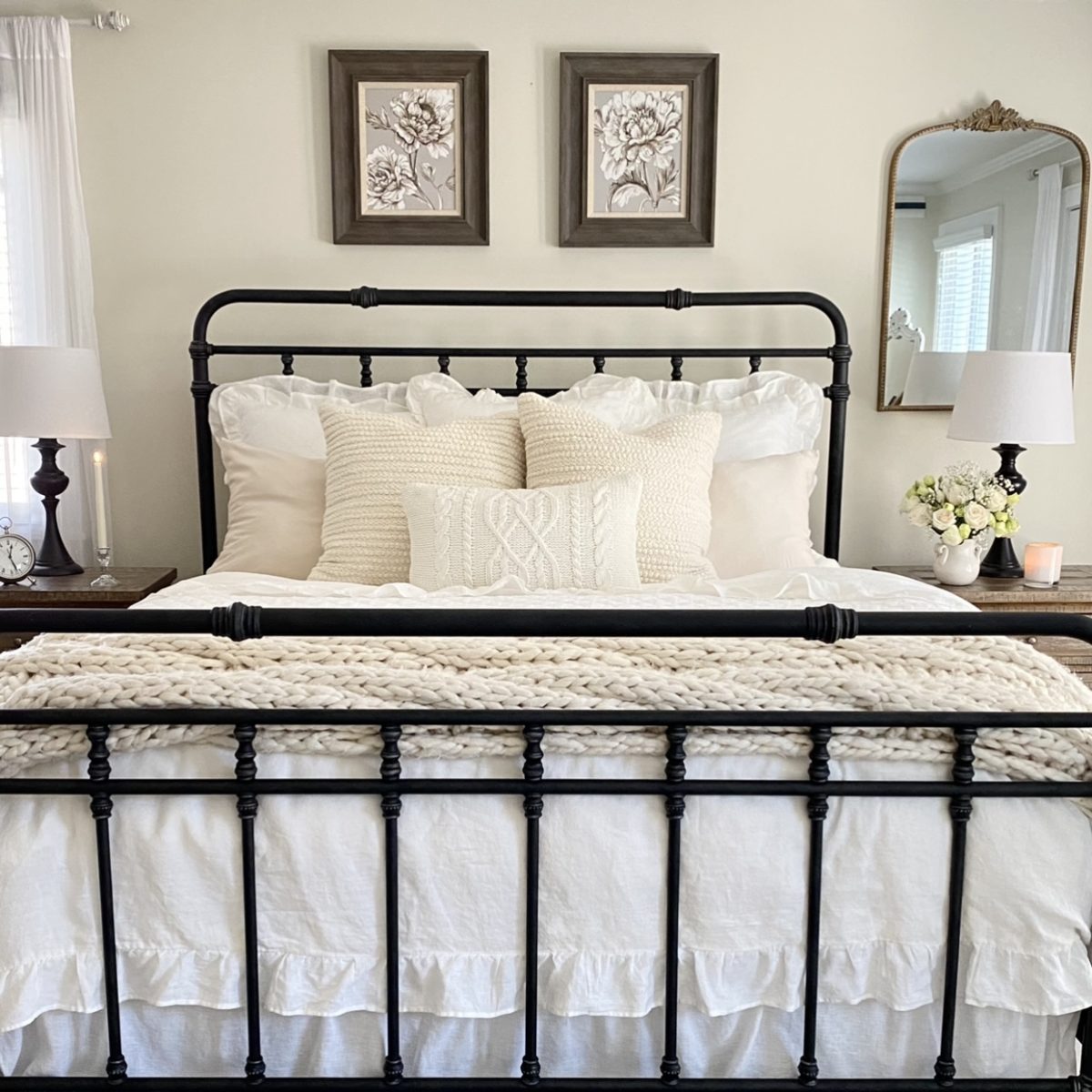 Layered winter white bedding on an iron bed.