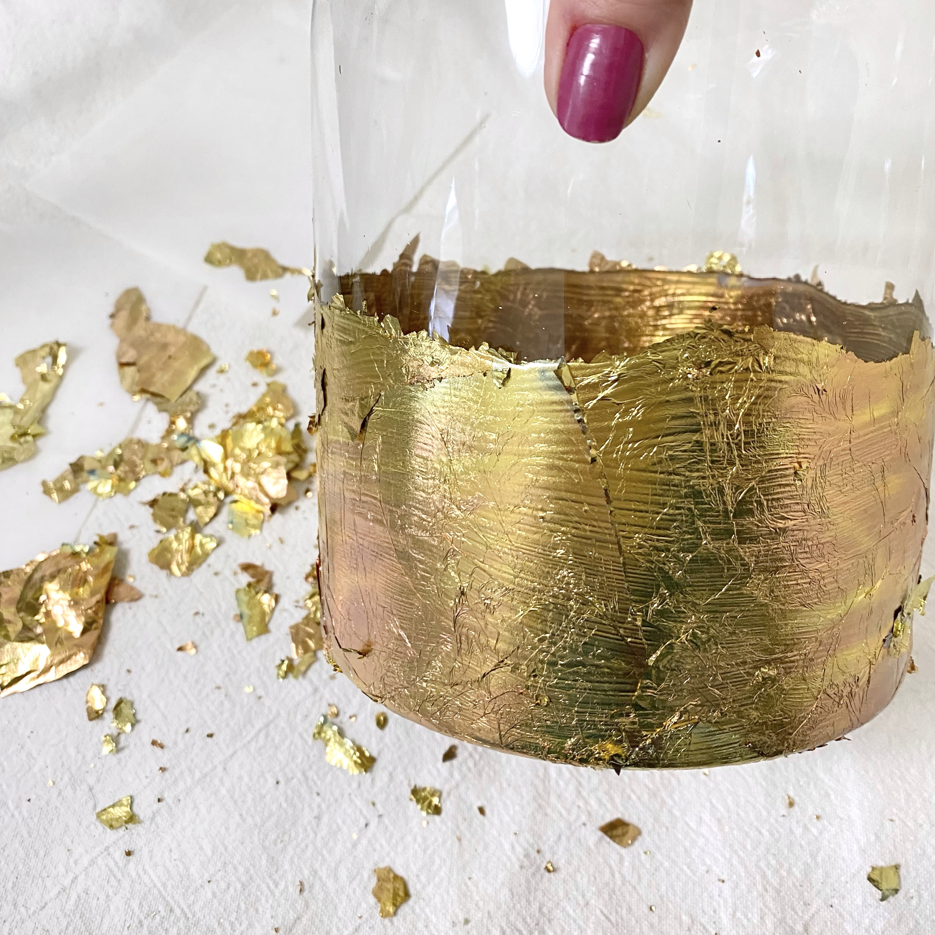 Applying the gold leaf to the glass vase.