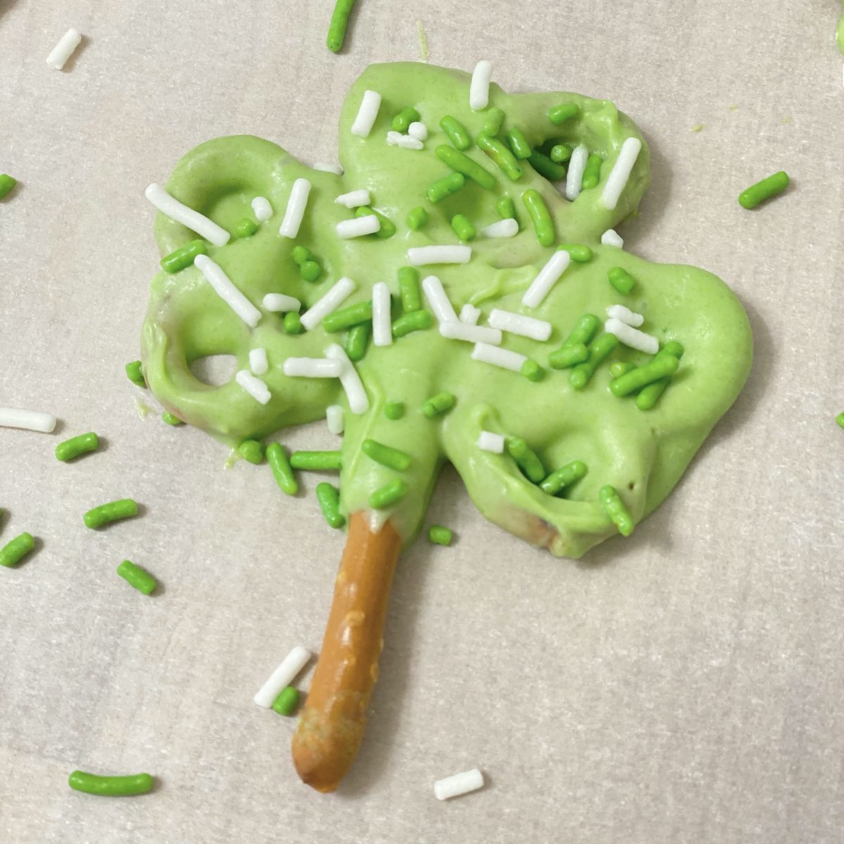 Pretzel shamrock with green chocolate and green and white sprinkles.