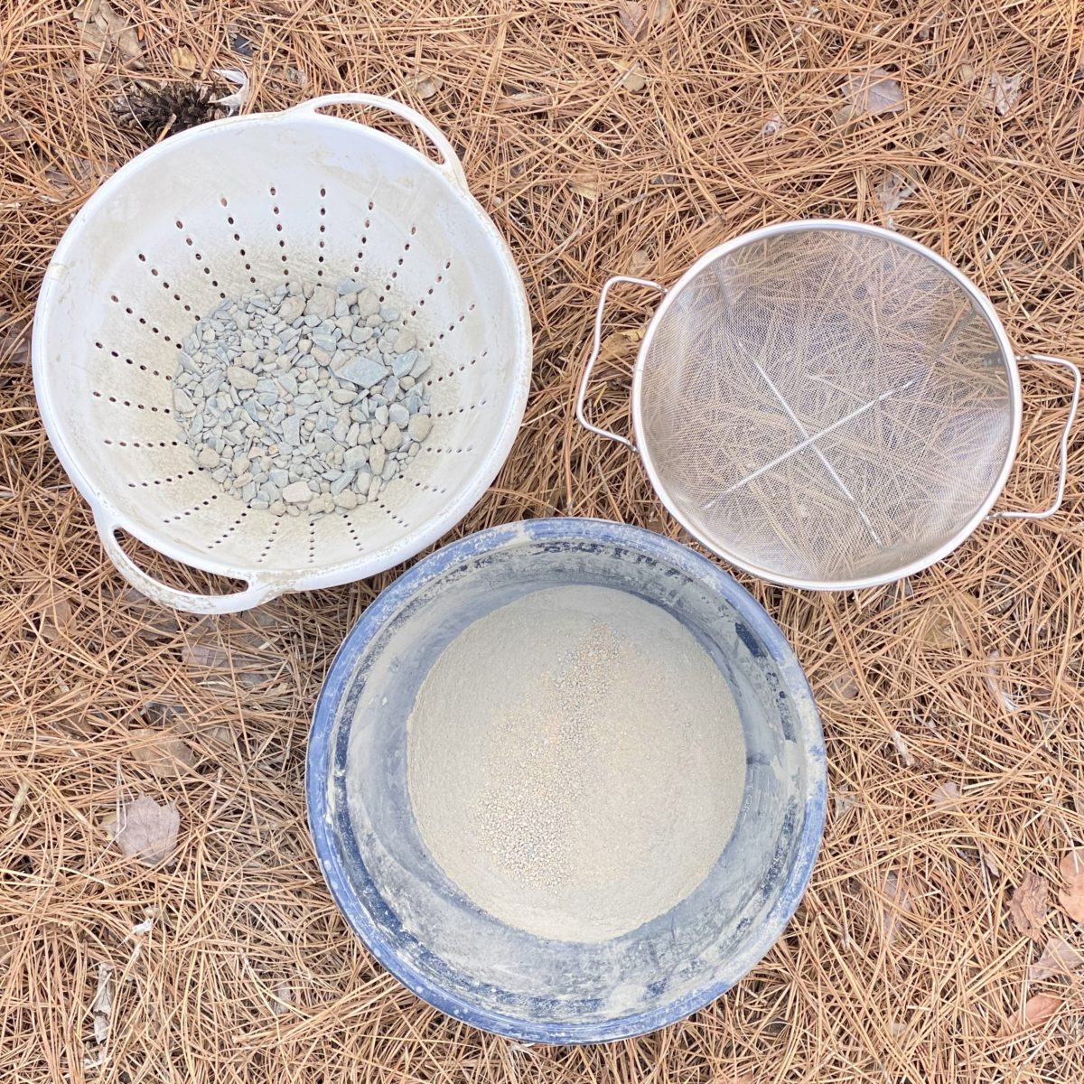 A colander, wire mesh sifter, and concrete that has been sifted in a bowl.