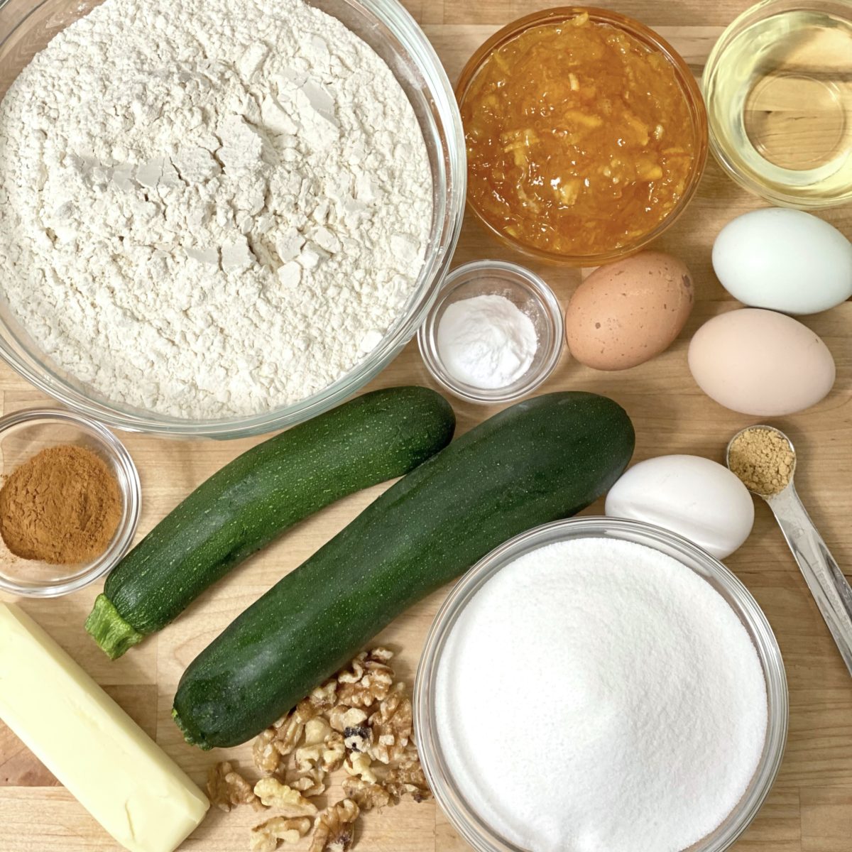 Ingredients in flowerpot zucchini bread including zucchini, flour, sugar, eggs, butter, cinnamon, and more.