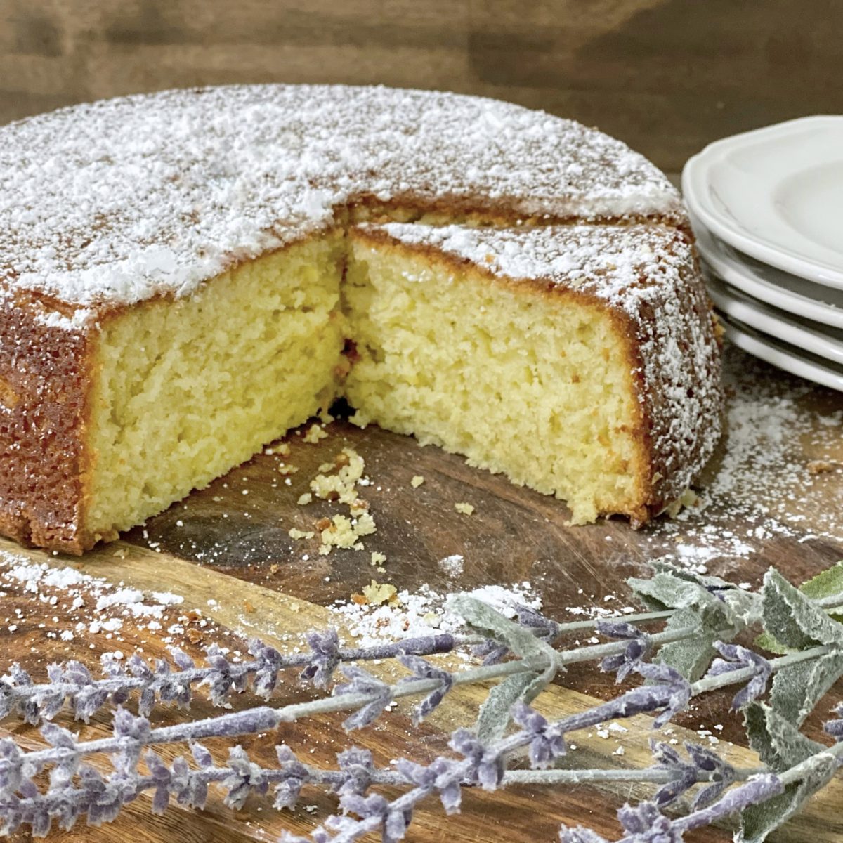 Lemon and lavender cake on a sliced with lavender in the foreground.