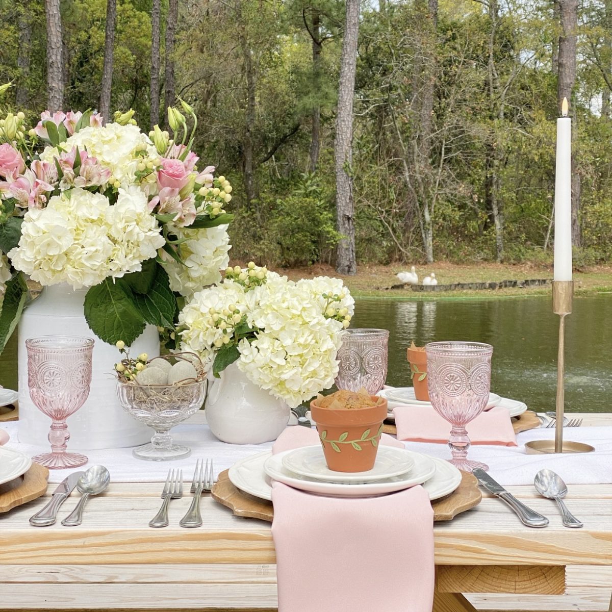 Simple spring table set by the pond with ducks in the background.