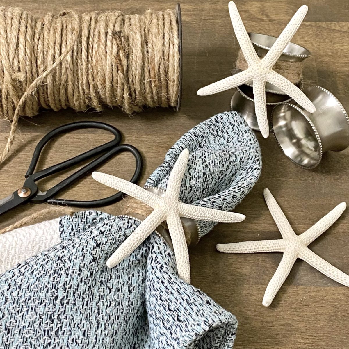 DIY coastal napkin rings made with silver napkin rings, twine, and starfish.