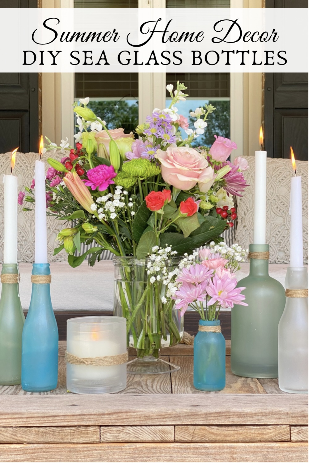 Pinterest Pin for DIY sea glass bottles styled onthe porch with fresh flowers and candles.