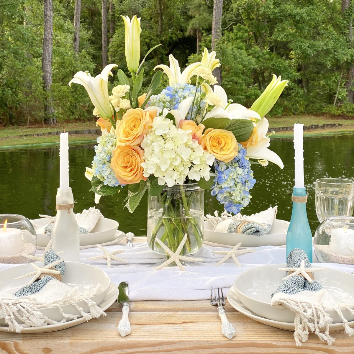 Floral centerpiece and sea glass bottles used as centerpiece.