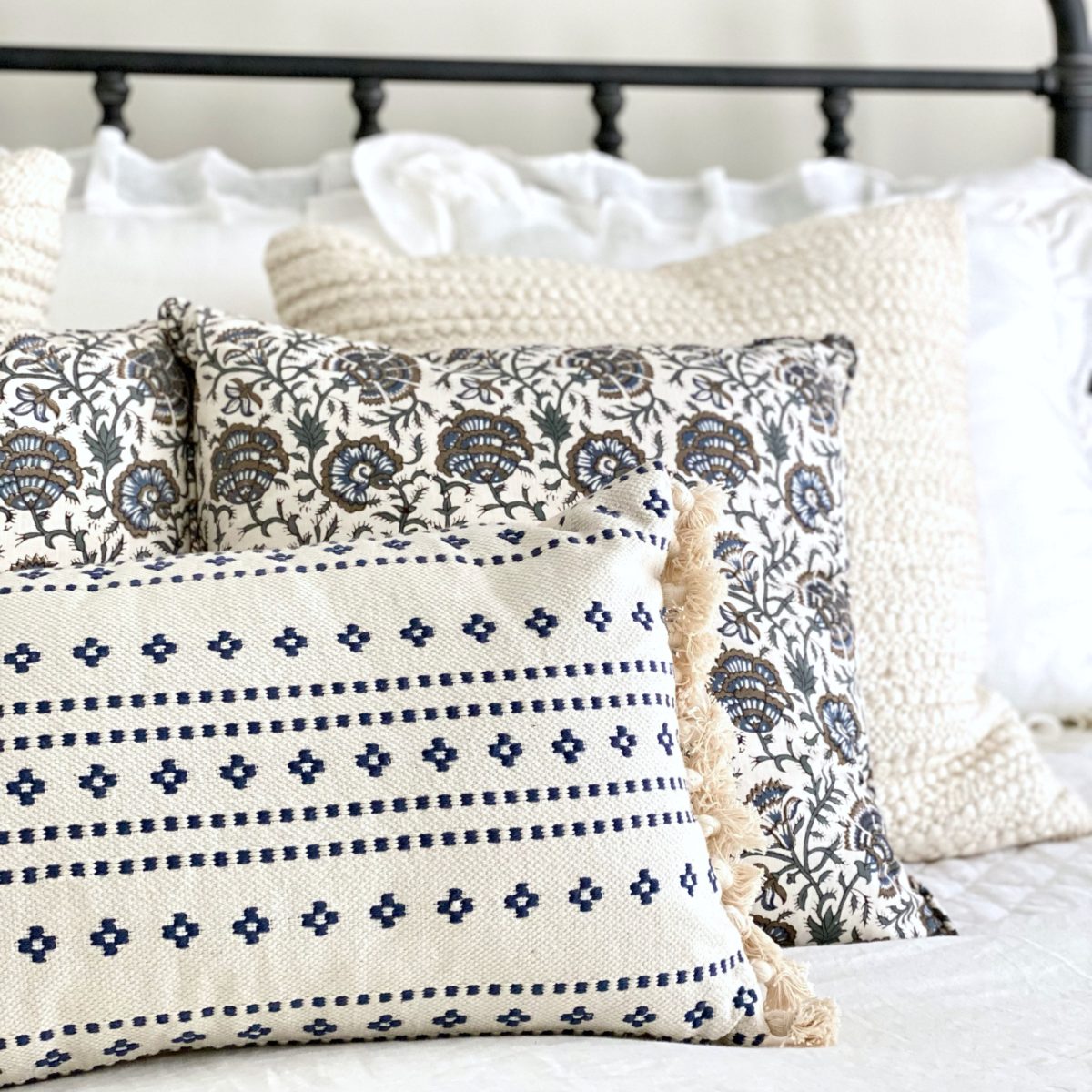 Blue and cream floral print pillows on the bed.