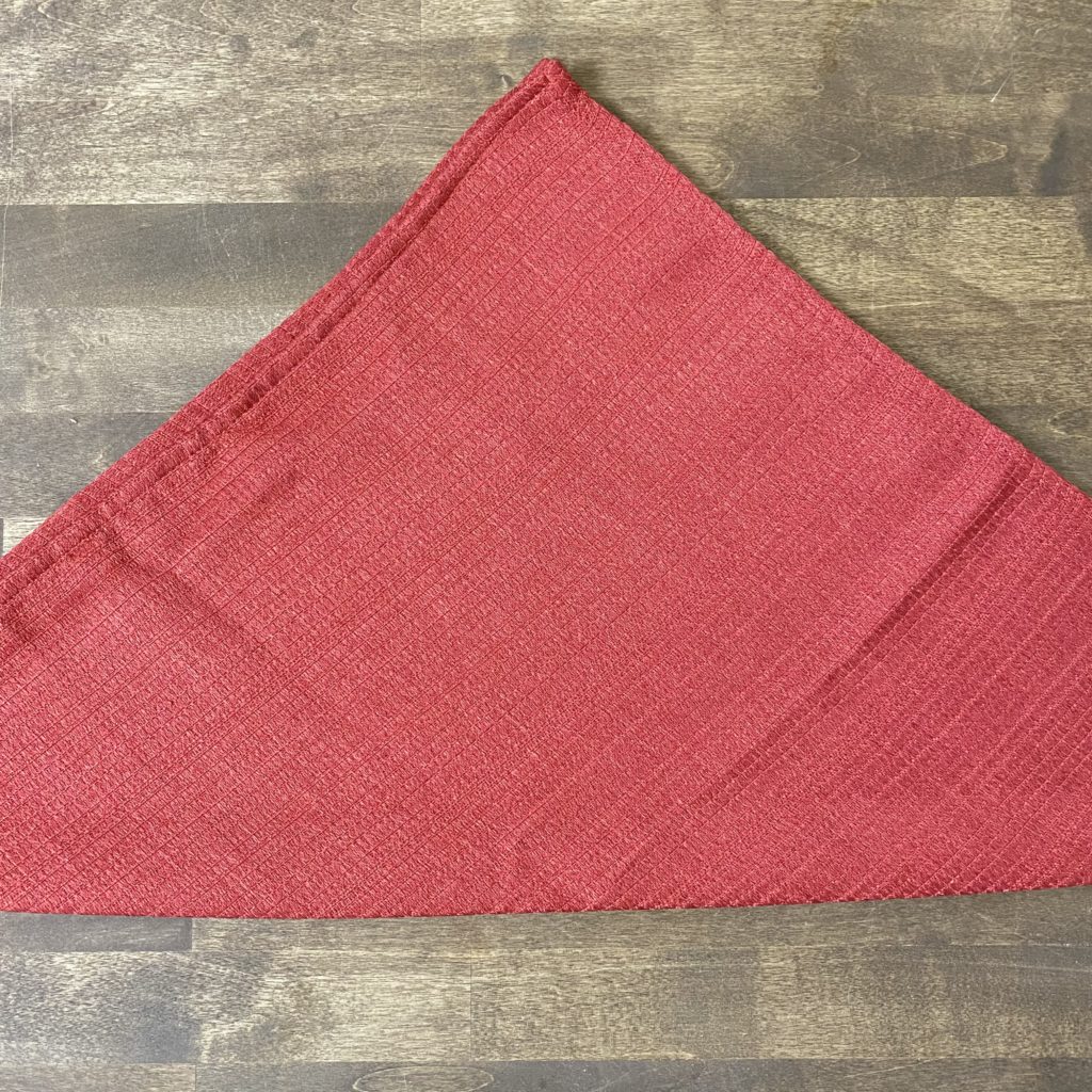 A red cloth napkin folded into a triangle.