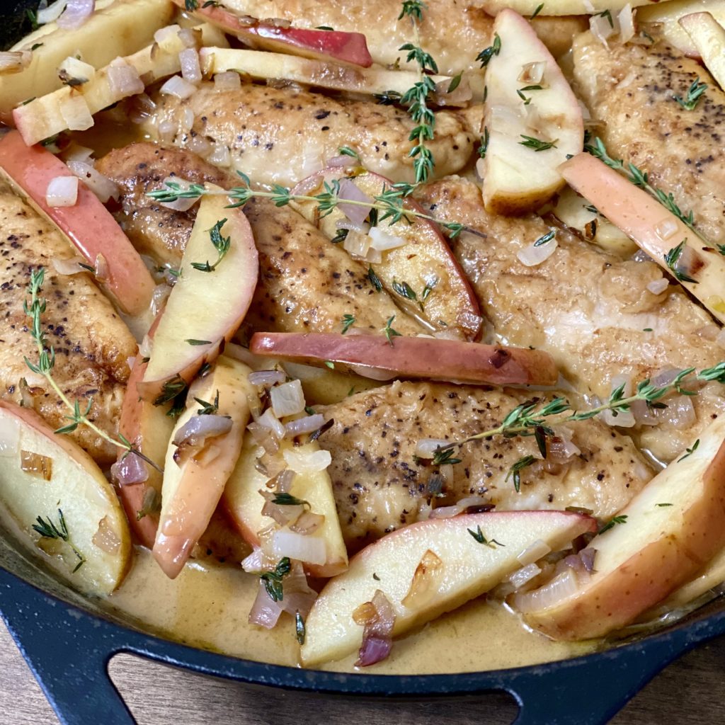 Chicken and Apples in Cider Cream Sauce in a skillet close-up.