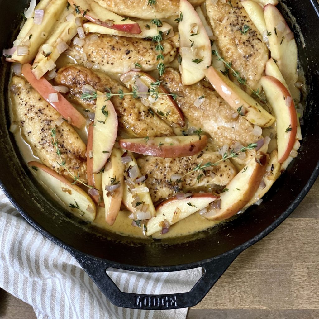 Chicken and Apples in Cider Cream Sauce in a skillet.