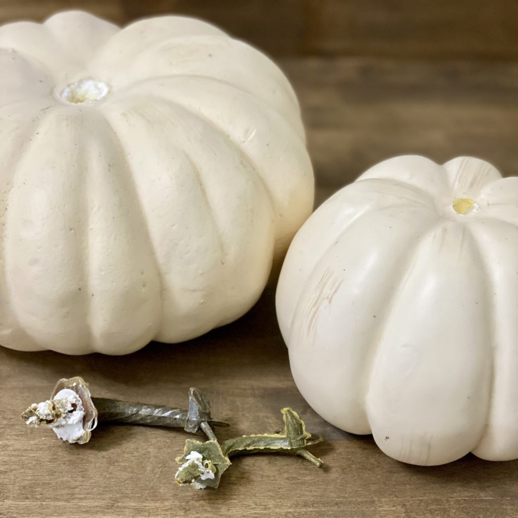 Two faux white pumpkins with the stems removed.