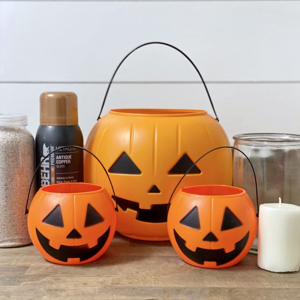 Everything you need to make a DIY Jack O’Lantern vase and candle holders including Jack O’Lantern trick-or-treat pails and spray paint.