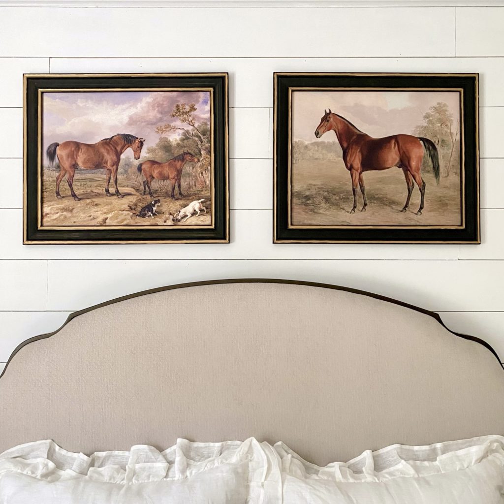 Close up photo of wall art above bed. There are two vintage inspired prints of horses.