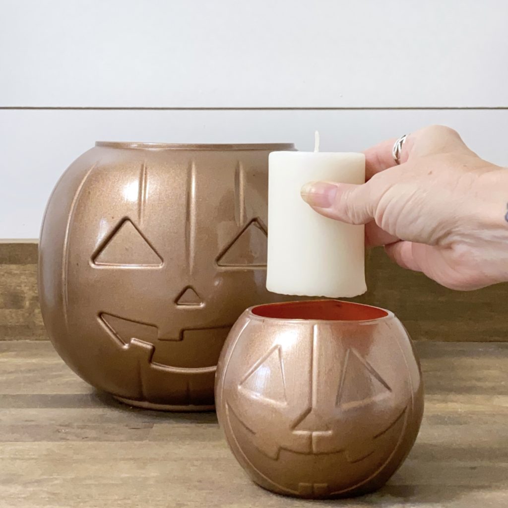 Placing a candle into the DIY Jack O’Lantern candle holder painted antique copper.