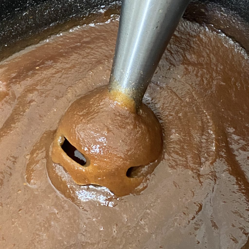 An immersion blender in the apple butter after it’s been emulsified. 