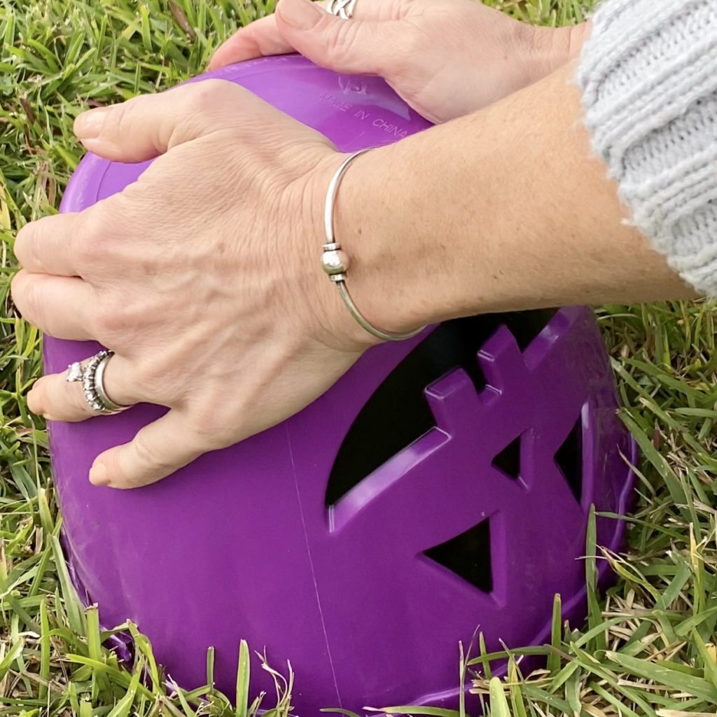Turning the Jack O’Lantern pail upside down to release the concrete planter.