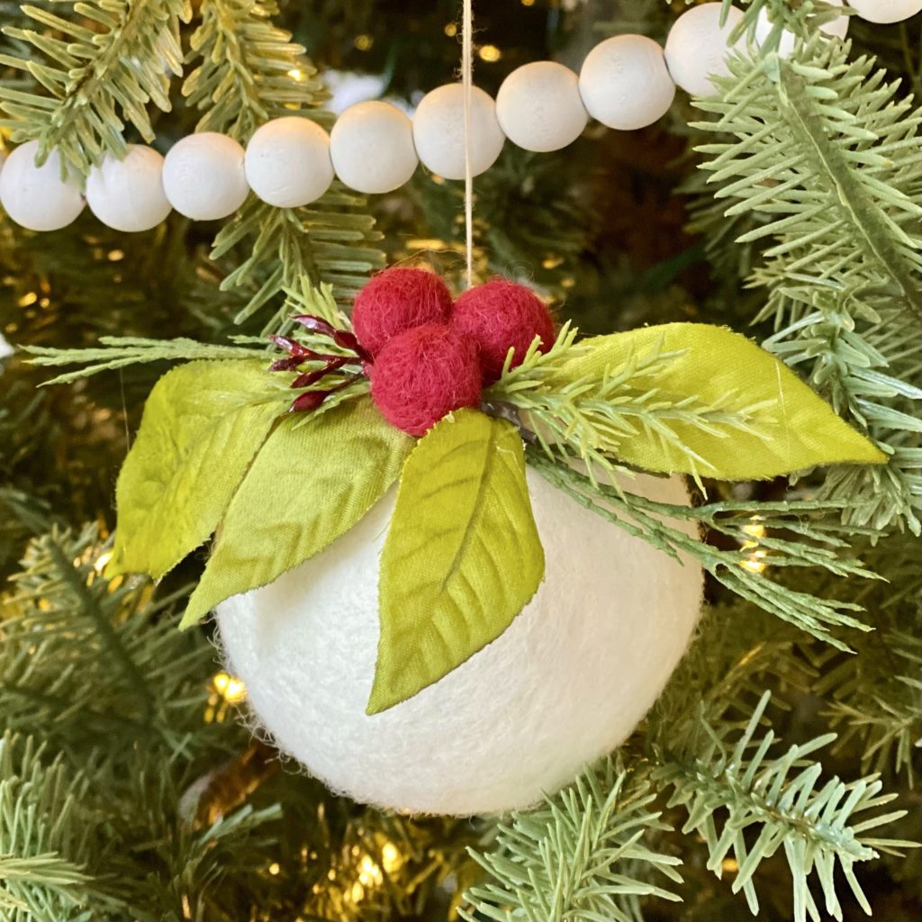 Wool felt ball DIY Christmas tree ornament on the tree.