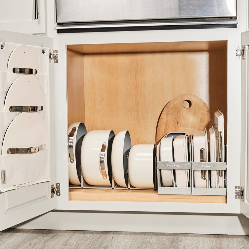Caraway pots, pans, bakeware, and lids stored away in a cabinet.