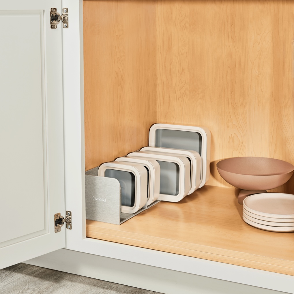 Caraway food storage containers in a cabinet.